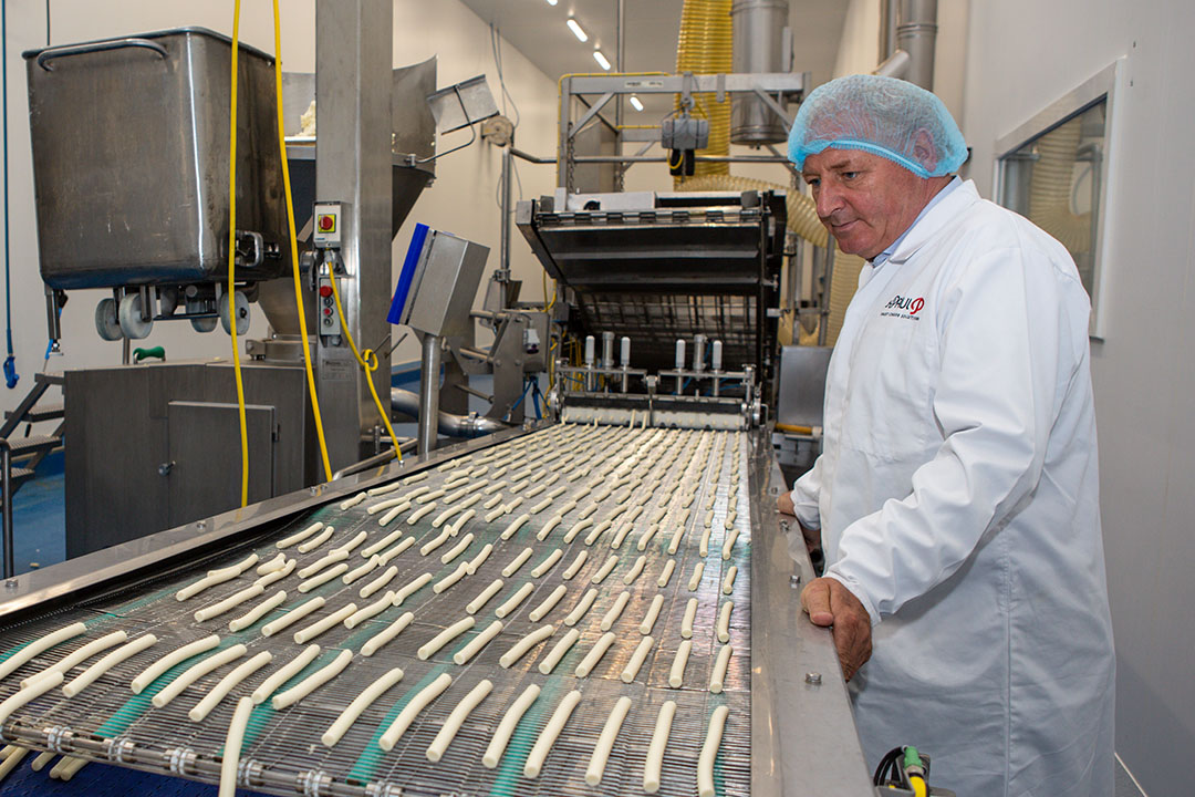 CEO Dieter Kuijl bij een van de productielijnen voor smeltkaas in de vestiging in Sint Jansteen. - Foto: Peter Roek