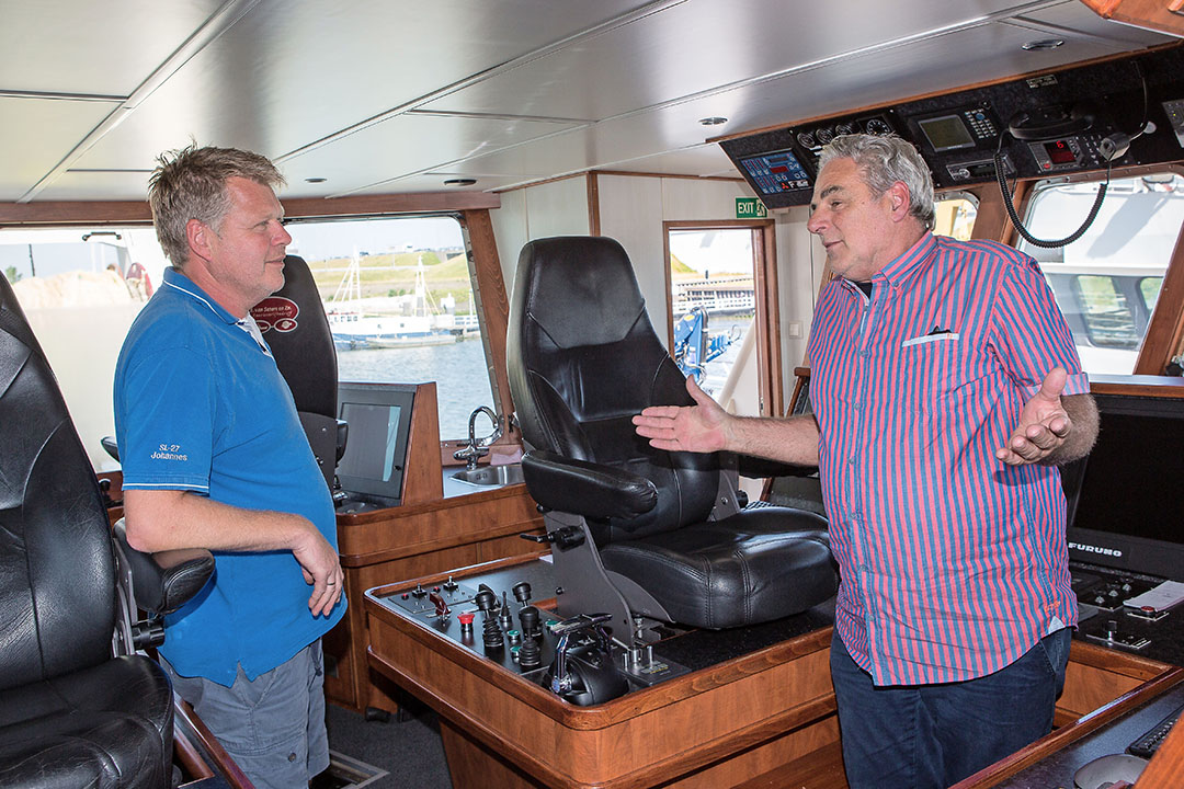 408240 Zeevisser Johan Seters (L/53) in gesprek met melkveehouder Wim van Leeuwen (R/65) in de stuurkamer van de vissersboot in Stellendam.